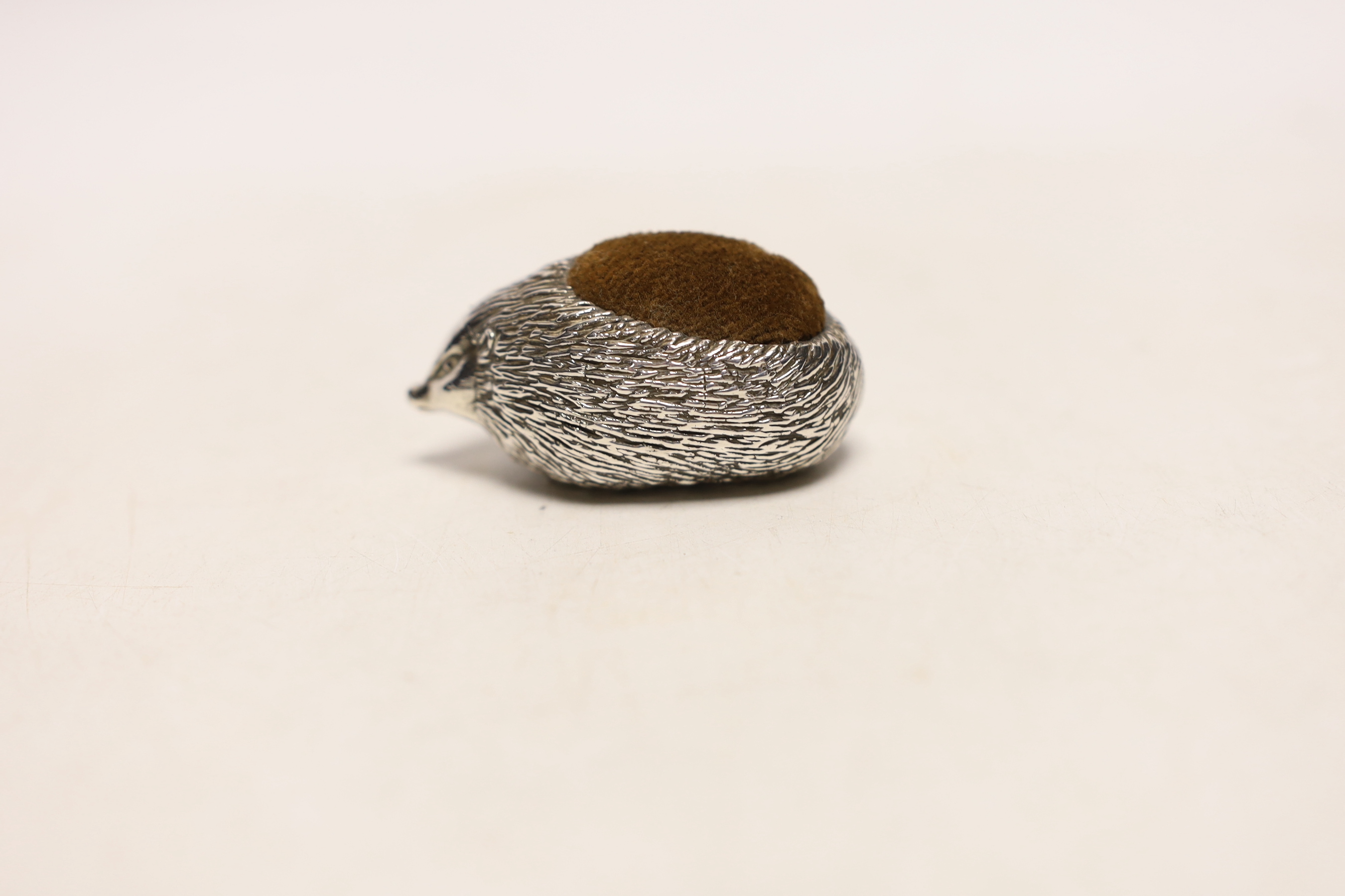 A modern novelty silver pin cushion modelled as a hedgehog, Ammonite Ltd, Birmingham, 1982, length 62mm.